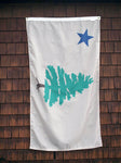 The original 1901 Maine State Flag consisting of a pine tree, a symbol of New England and a North Star, a symbol of freedom are printed against a pale tan background. Flag hangs against weathered barn shingles.